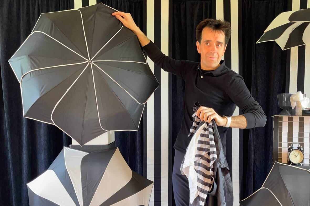 Photo de Monsieur Fred en pleine représentation magique, entouré de son décor et d’effets visuels d’illusion d’optique pour les fêtes de fin d'année