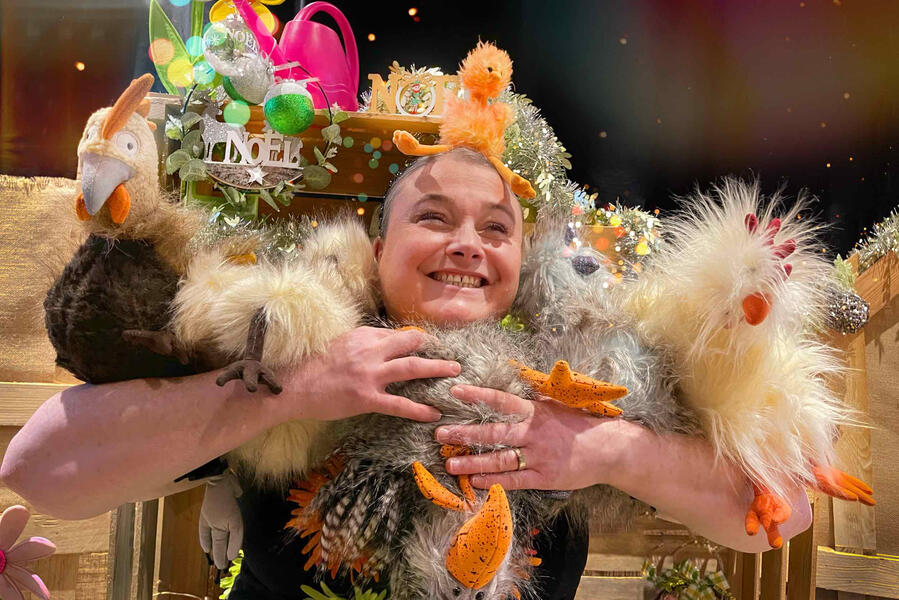 La comédienne conteuse tire dans ses bras, ses poules et ses coques avec un poussin sur la tête pour les fêtes de fin d'année. Ambiance festive assurée.