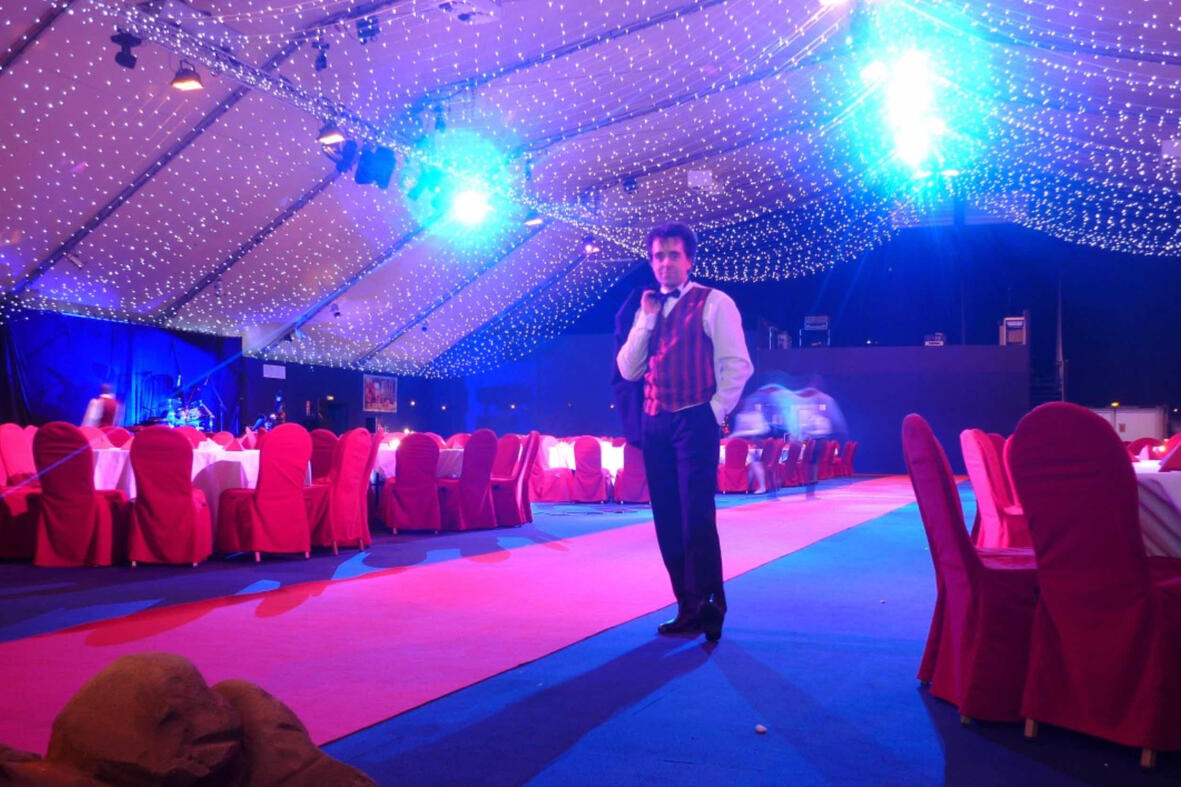 Animation magie de close-up Magicien en pleine prestation de close-up magie, créant la surprise parmi les invités pendant les fêtes de Noël.