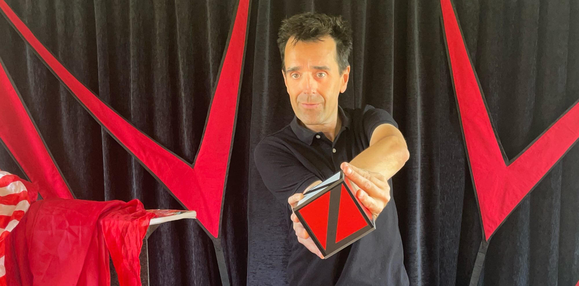 Spik Spakkk ! Monsieur Fred fait apparaître un lapin en peluche à partir d’un foulard, entouré de ballons rouges, lors d’un numéro de magie pour enfants pour l'arbre de Noël d'une mairie.