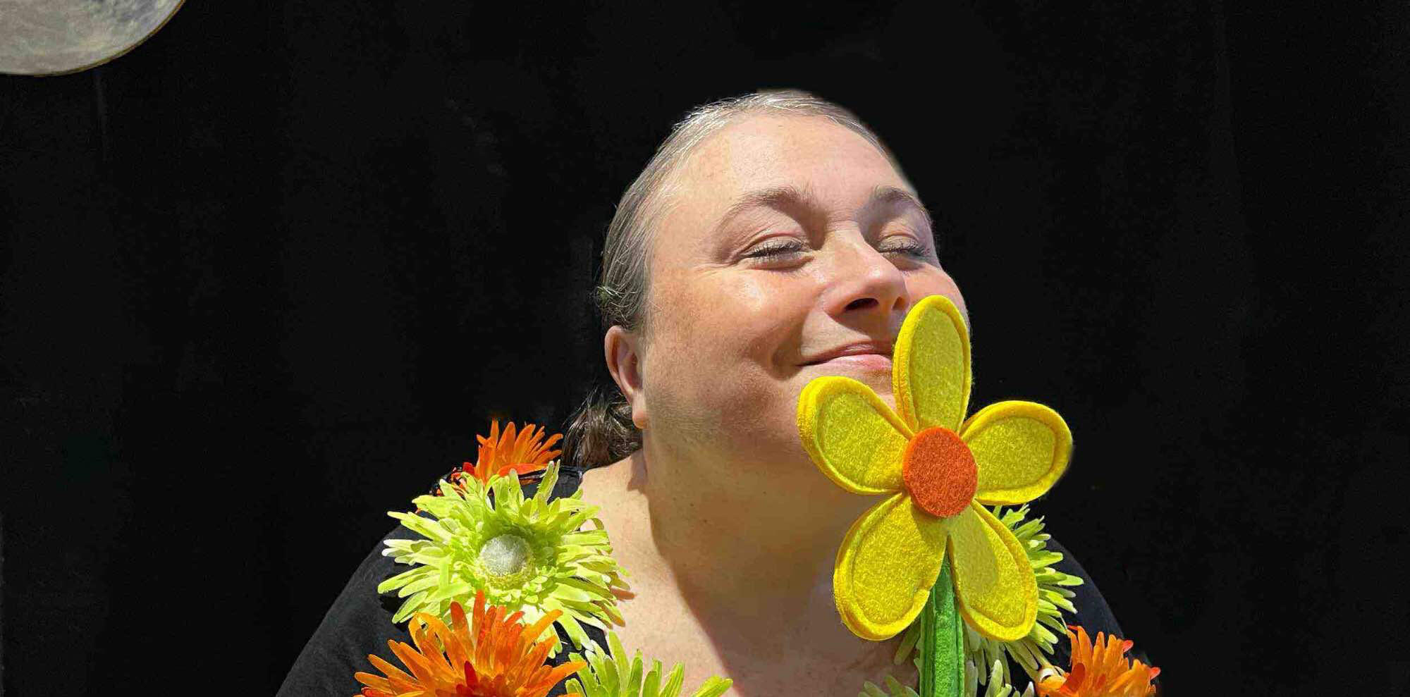 Spectacle j'me cache ! Aurore la conteuse sur scène, entourée de ses personnages et accessoires dans un décor en bois fleuri pendant une représentation lors des célébrations de Noël et Nouvel An.